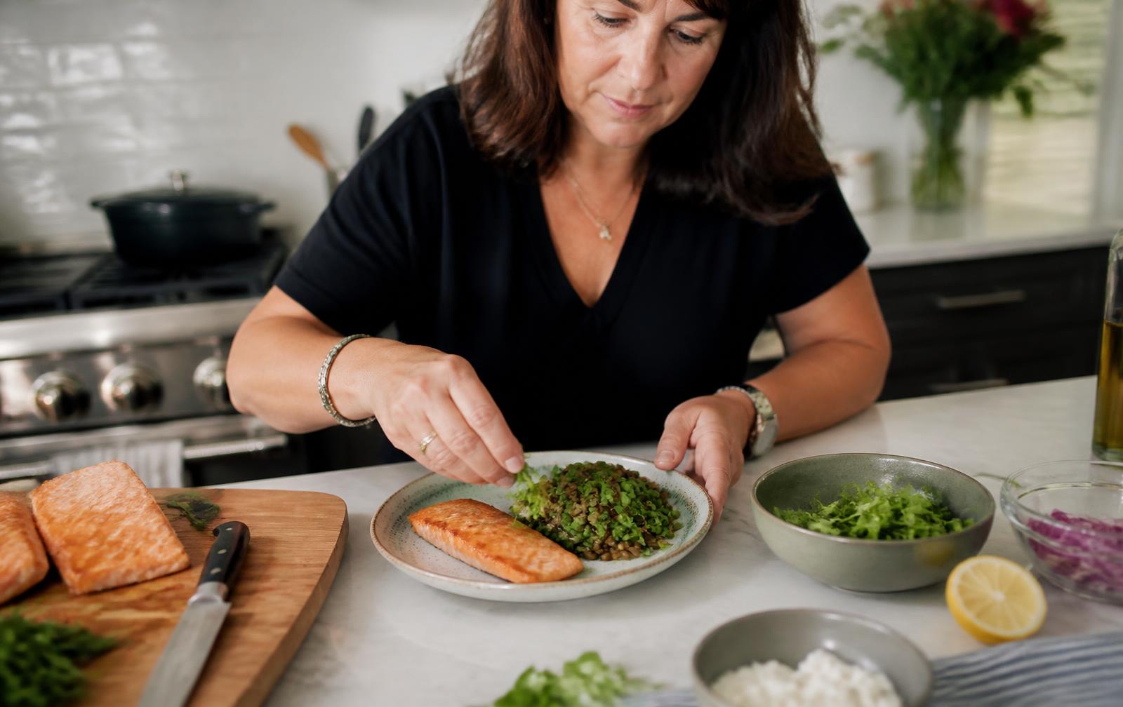 Plate of grilled salmon, greens and lentils on a linen table